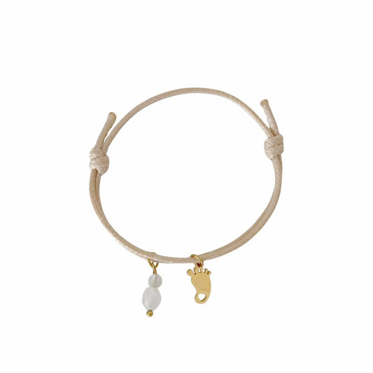 "Studiofoto van een beige waxkoord armbandje met een goudkleurige babyvoetje-bedel en edelstenen, getoond op een witte achtergrond."