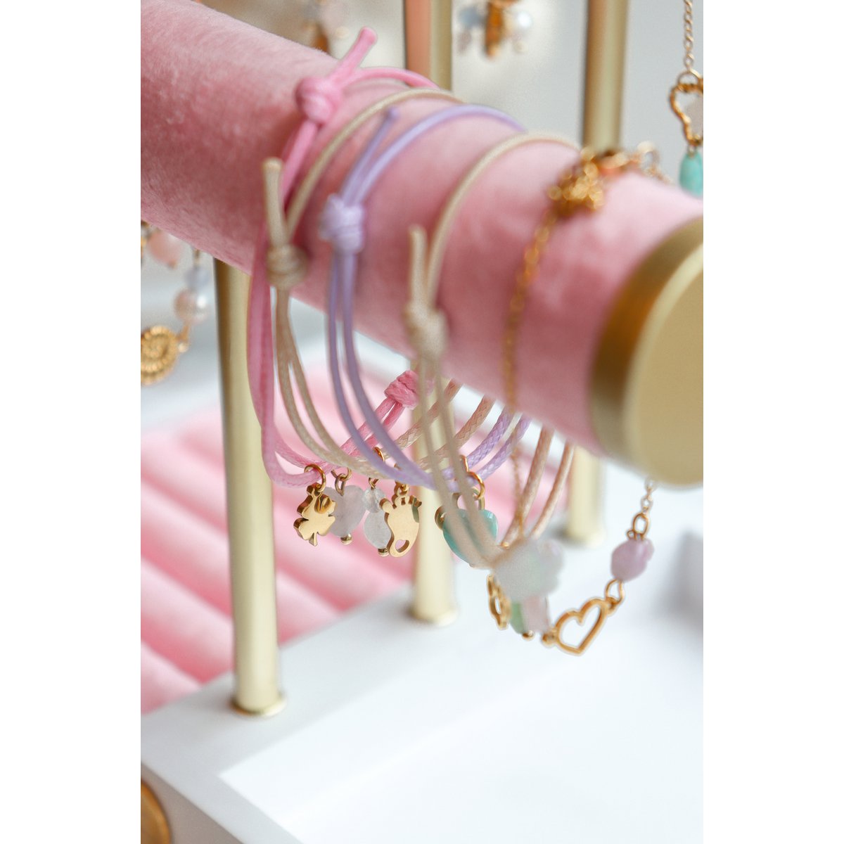 een collectie vrolijke waxkoord armbandjes met verschillende bedeltjes, perfect als cadeau-inspiratie."