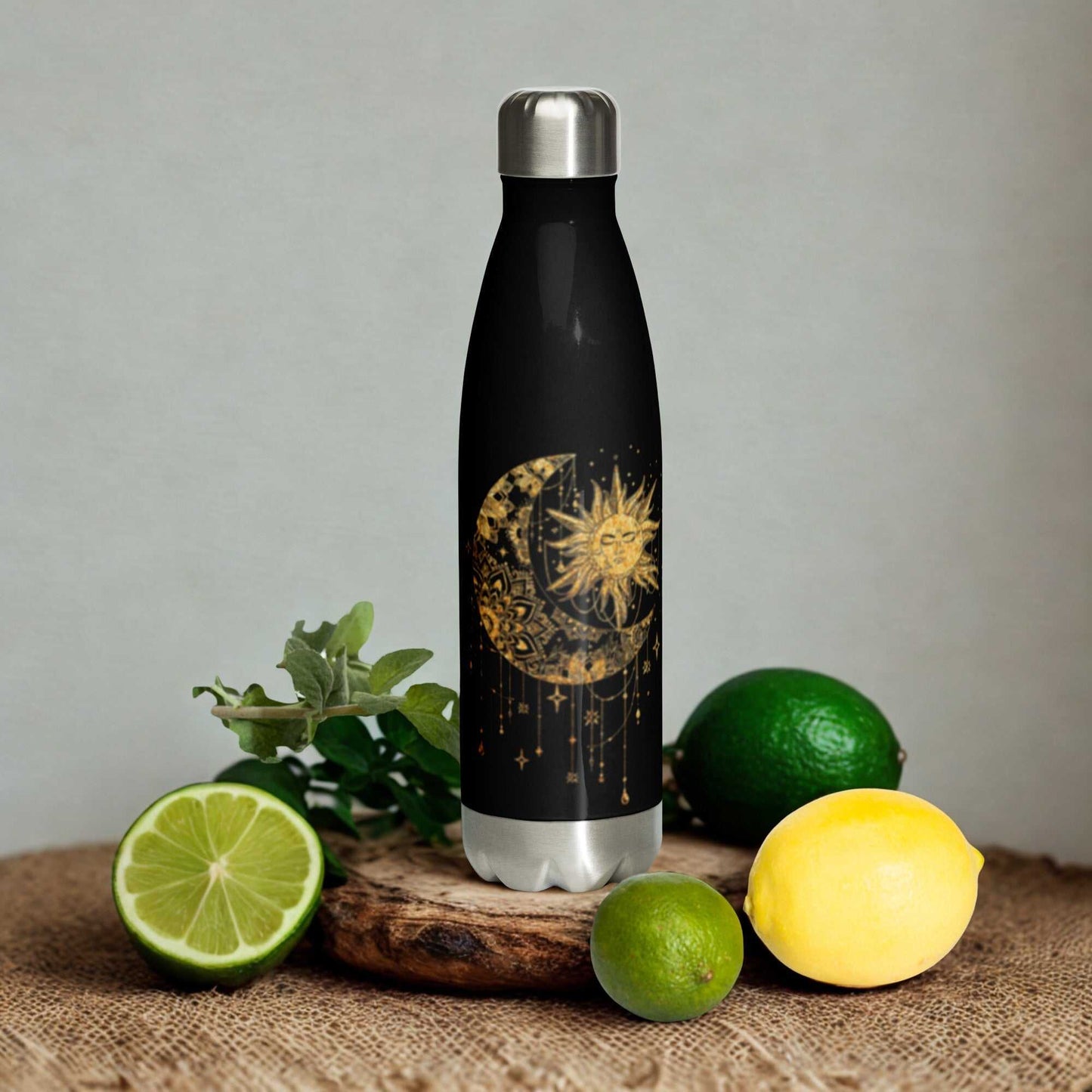 Mystic Sun and Moon Stainless Steel Water Bottle with celestial design surrounded by fresh citrus fruits
