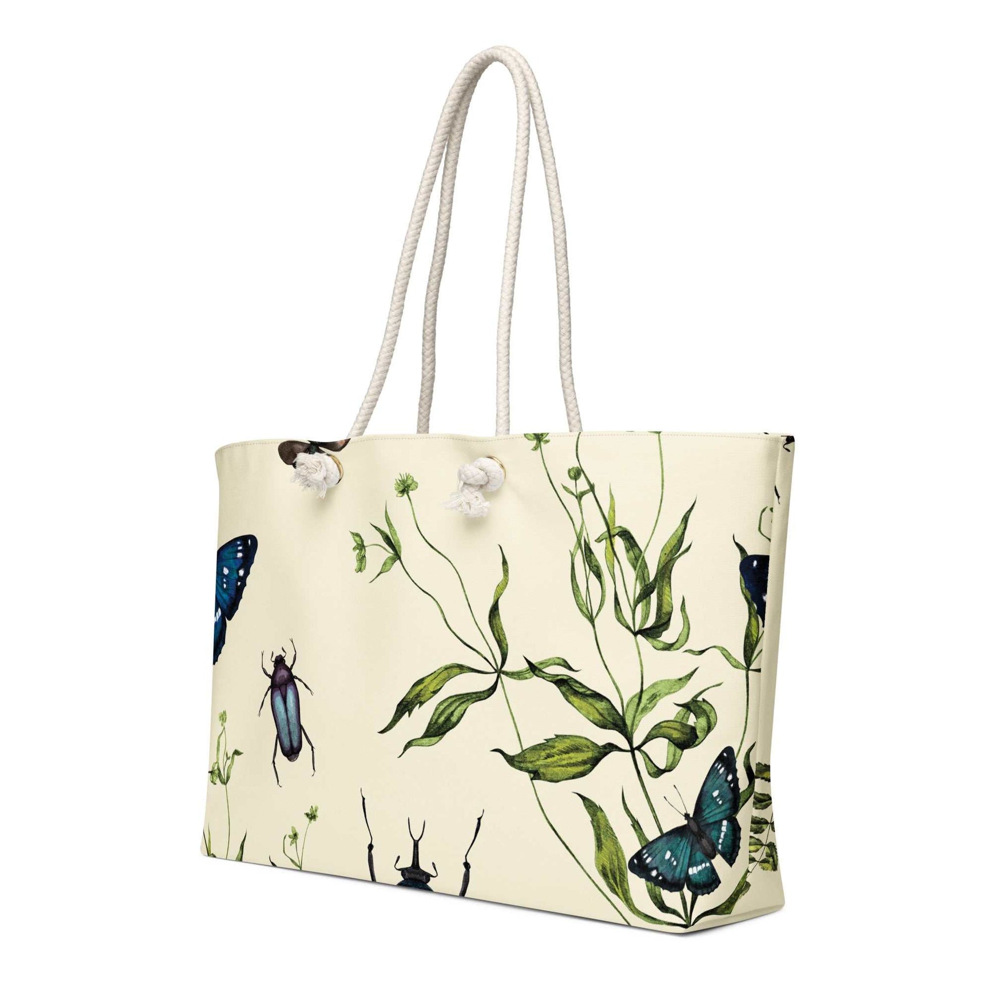 Oversized weekender bag with vintage botanical artwork featuring butterflies and beetles, cream background, and rope handles