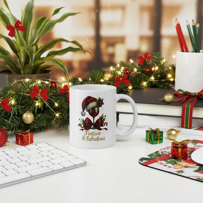 Festive & Fabulous Christmas mug with holiday wine glass design on white ceramic surrounded by Christmas decorations on a desk