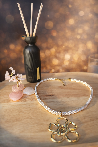 Luxe witte ketting met gedraaid koord en gouden bloemhanger.