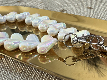 Wit marmeren acryl kralen hartjes koord van Glow Mystic in Style op een goudkleurige schaal.