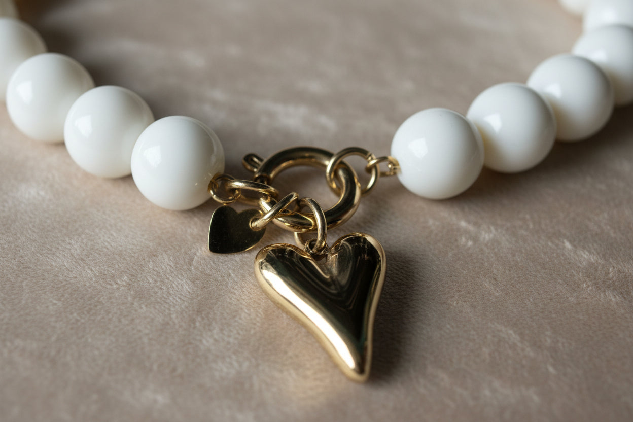 Gedetailleerde foto van de goudkleurige Stainless Steel kliksluiting van de Glow Mystic ketting, die laat zien hoe je de harthanger kunt wisselen voor een andere hanger."