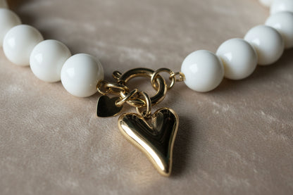 Gedetailleerde foto van de goudkleurige Stainless Steel kliksluiting van de Glow Mystic ketting, die laat zien hoe je de harthanger kunt wisselen voor een andere hanger."