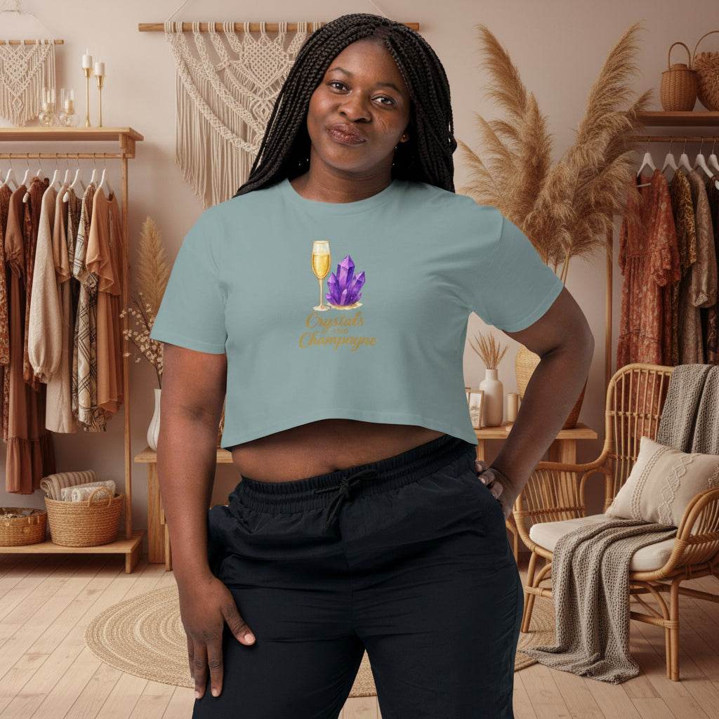 Woman wearing Crystals and Champagne Women's Crop T-Shirt with champagne glass and purple crystals design in cozy room setting