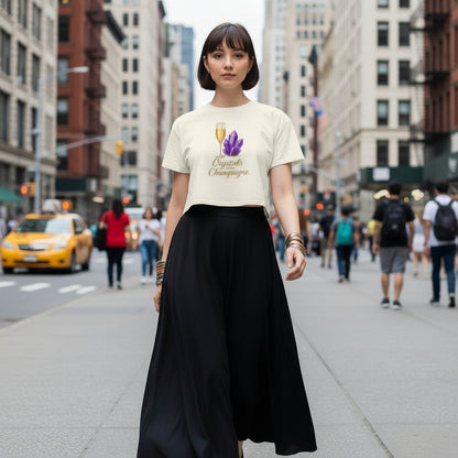 Woman wearing Crystals and Champagne Women's Crop T-Shirt with champagne glass and purple crystals print in urban setting