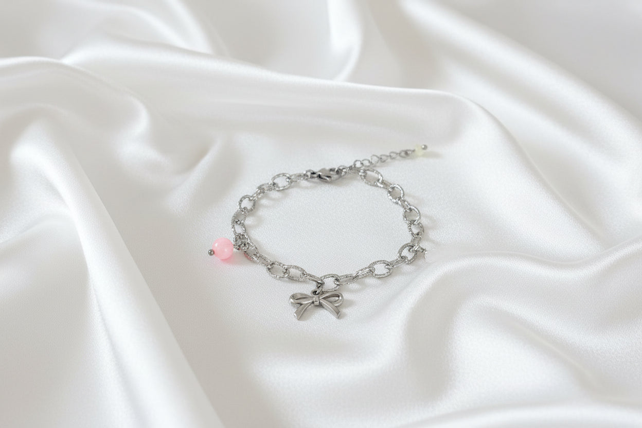 “Speelse statement armband met strikje, schelp en jade op satijnen stof”