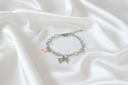 “Speelse statement armband met strikje, schelp en jade op satijnen stof”