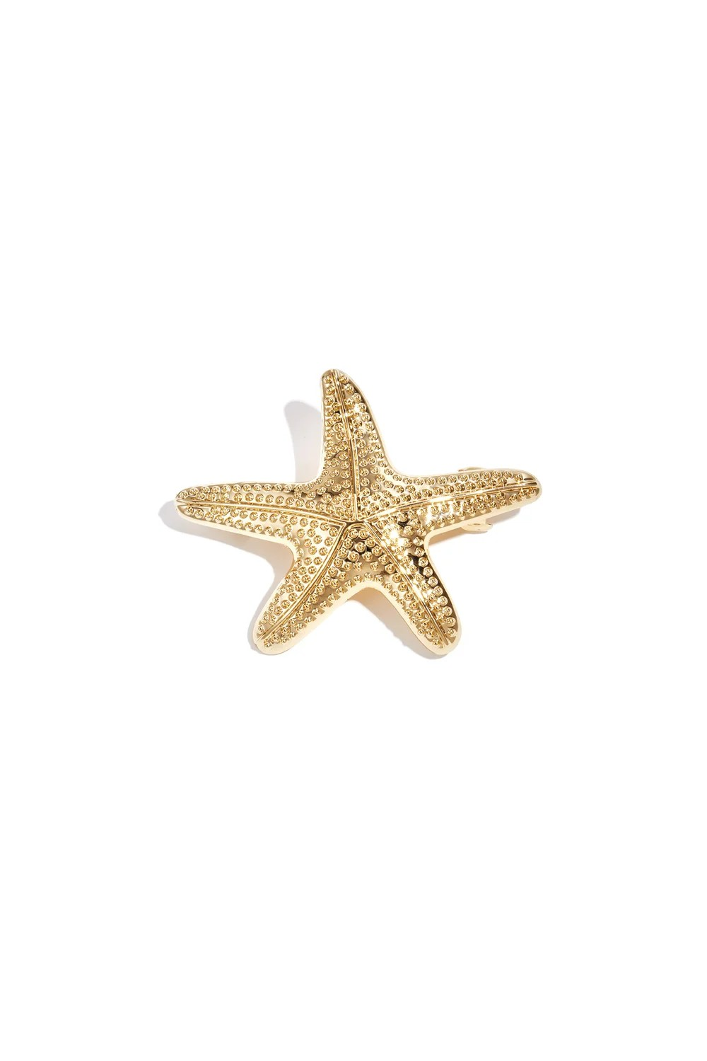 Bovenaanzicht van de gouden metalen haarschuif in de vorm van een gedetailleerde zeester op een witte achtergrond.