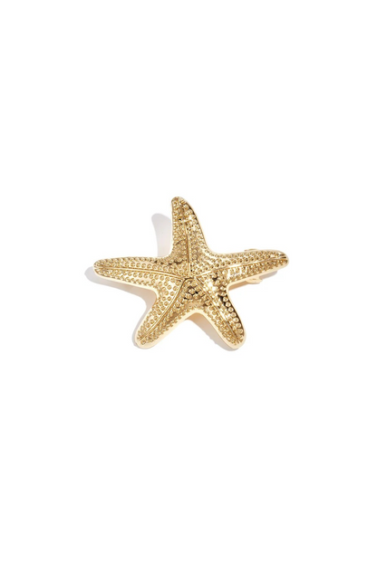 Bovenaanzicht van de gouden metalen haarschuif in de vorm van een gedetailleerde zeester op een witte achtergrond.