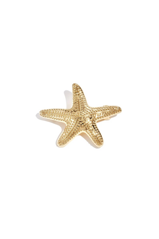 Bovenaanzicht van de gouden metalen haarschuif in de vorm van een gedetailleerde zeester op een witte achtergrond.