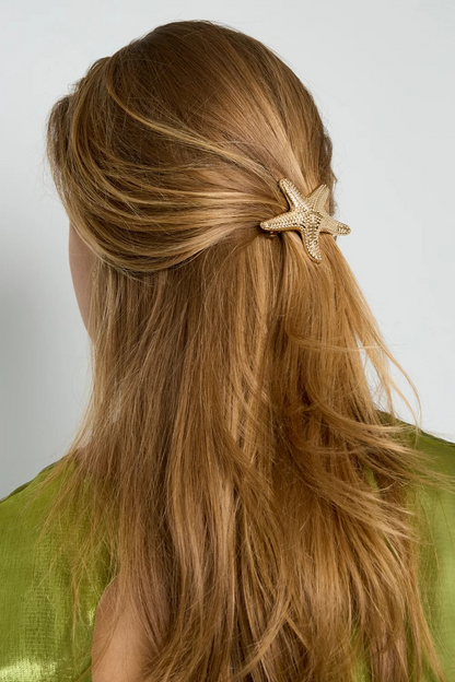Model van de achterkant met lichtbruin haar in een half-up look, versierd met een gouden metalen zeester haarschuif van Glow Mystic in Style.