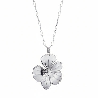 Zilverkleurige lange stainless steel ketting van Glow Mystic in Style met een grote abstracte bloemenhanger tegen een witte achtergrond.